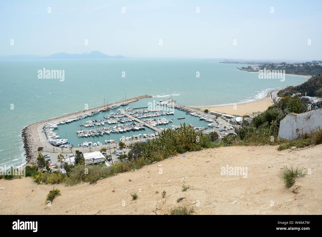 Un punto di vista collina che si affaccia sulla acquamarina Mare Mediterraneo e la barca in porto il sobborgo di Sidi Bou Said, Tunisi, Tunisia. Foto Stock