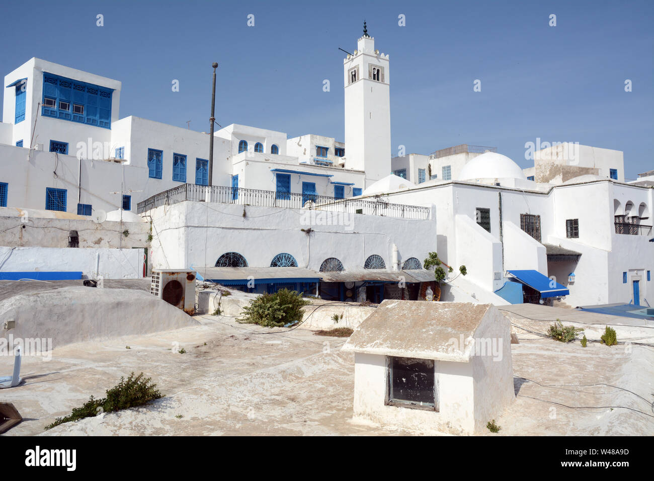 Tradizionale imbiancato minareto della moschea, e case residenziali nella medina della città turistica e sobborgo di Sidi Bou Said, Tunisi, Tunisia. Foto Stock