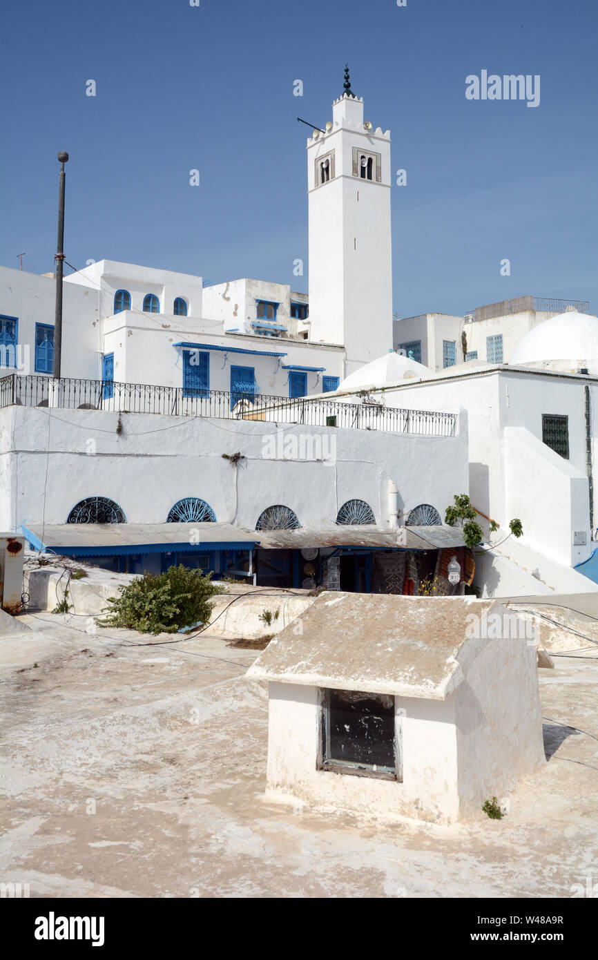Tradizionale imbiancato minareto della moschea, e case residenziali nella medina della città turistica e sobborgo di Sidi Bou Said, Tunisi, Tunisia. Foto Stock