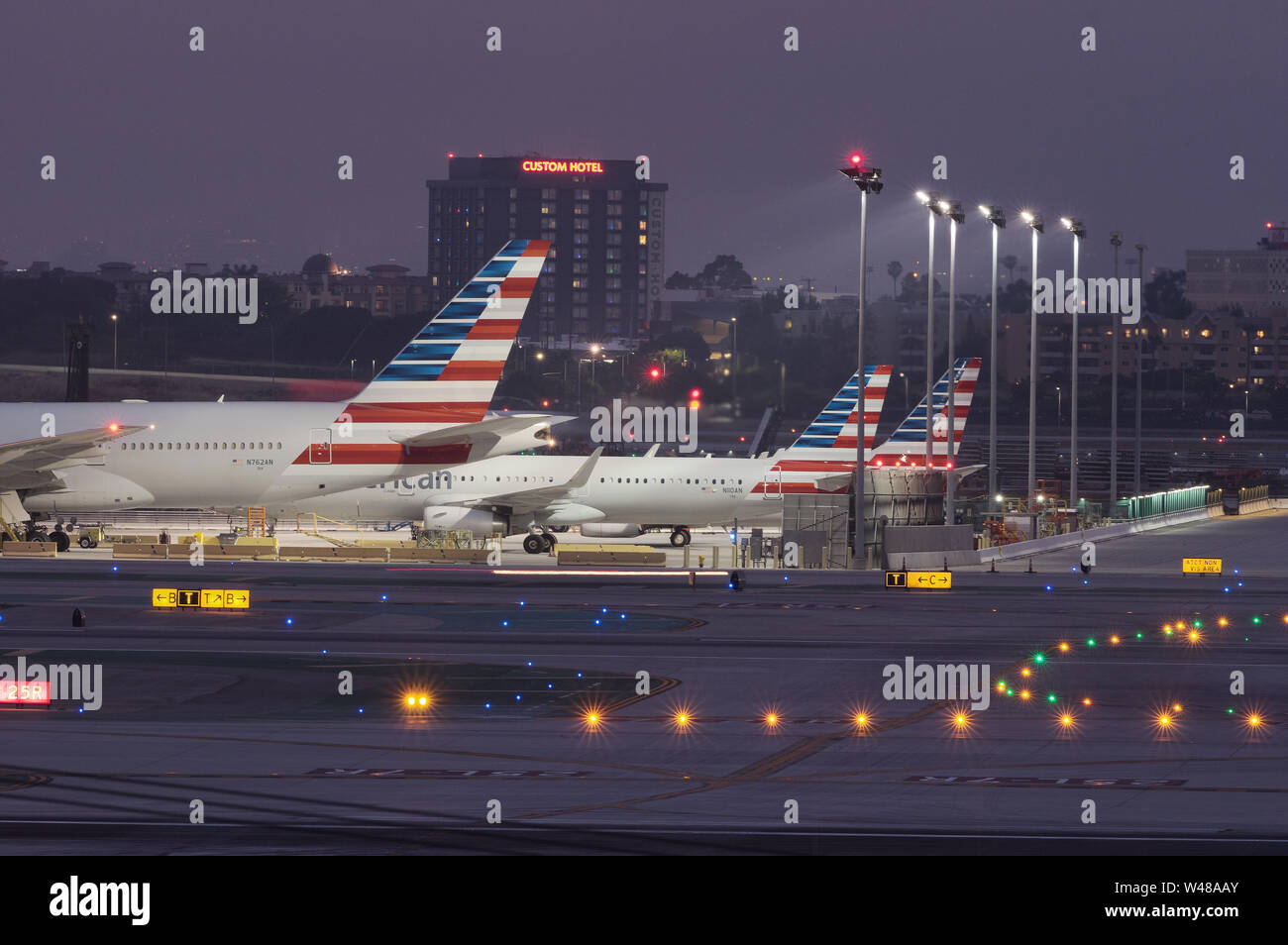 Coda di jet American Airlines parcheggiati all'aeroporto internazionale di Los Angeles, LAX, al tramonto. Foto Stock