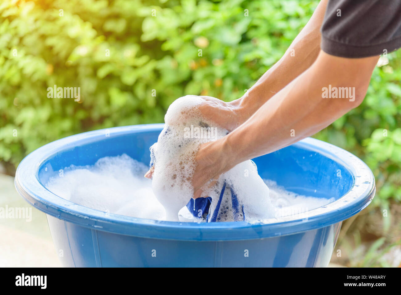 Lavaggio a mano vestiti nel bacino di blu Foto Stock