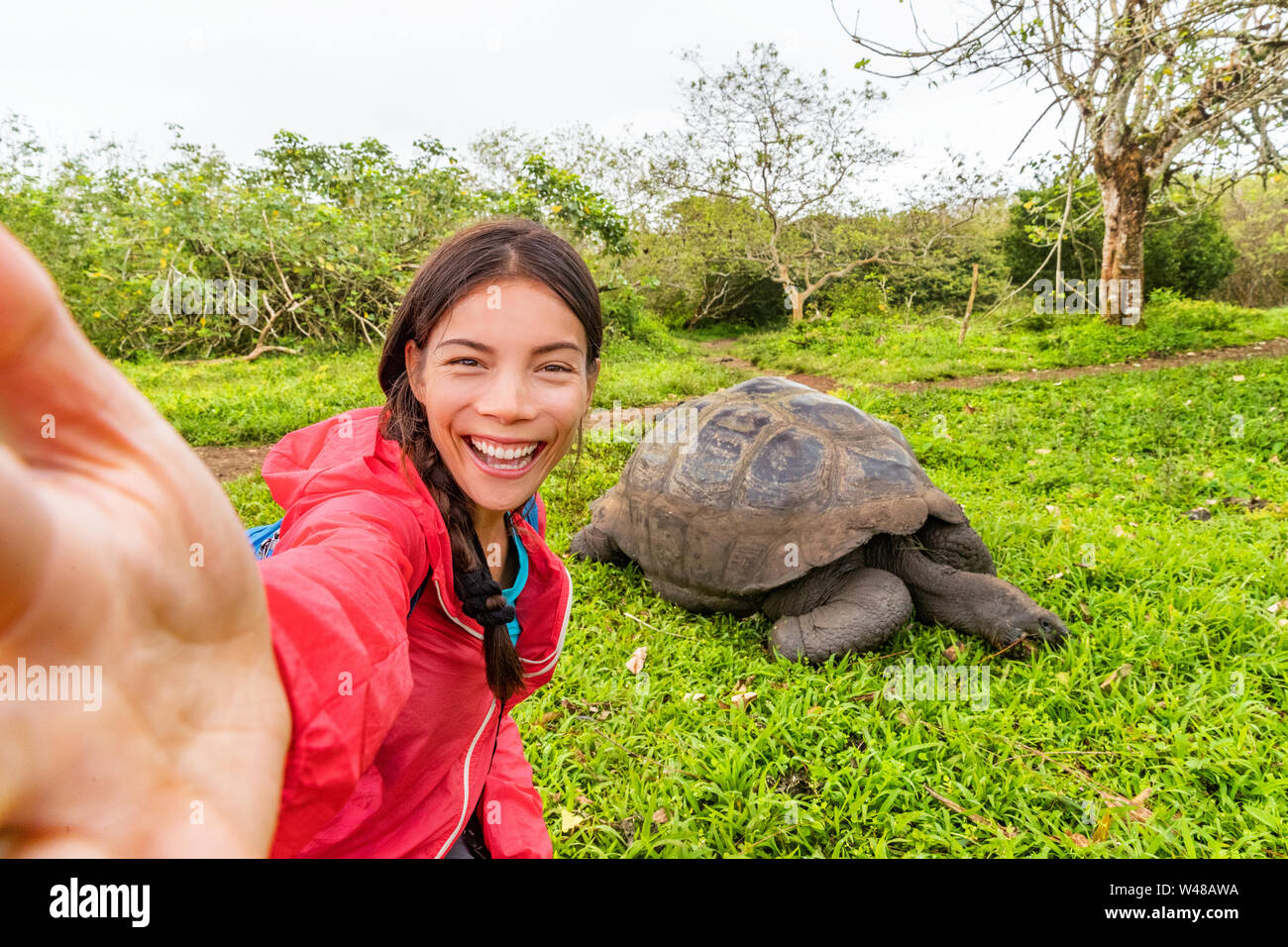 Avventura di viaggio turistico a isole Galapagos tenendo selfie phot da tartarughe giganti sull isola di Santa Cruz in Isole Galapagos. Gli animali e la natura in Galápagos highlands. Foto Stock