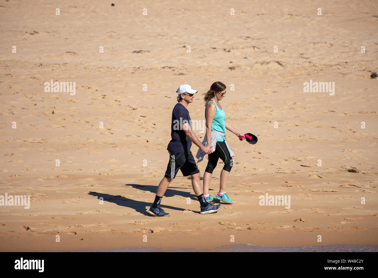 L uomo e la donna a piedi lungo la spiaggia di esercitare e mantenere fit,Sydney , Australia Foto Stock