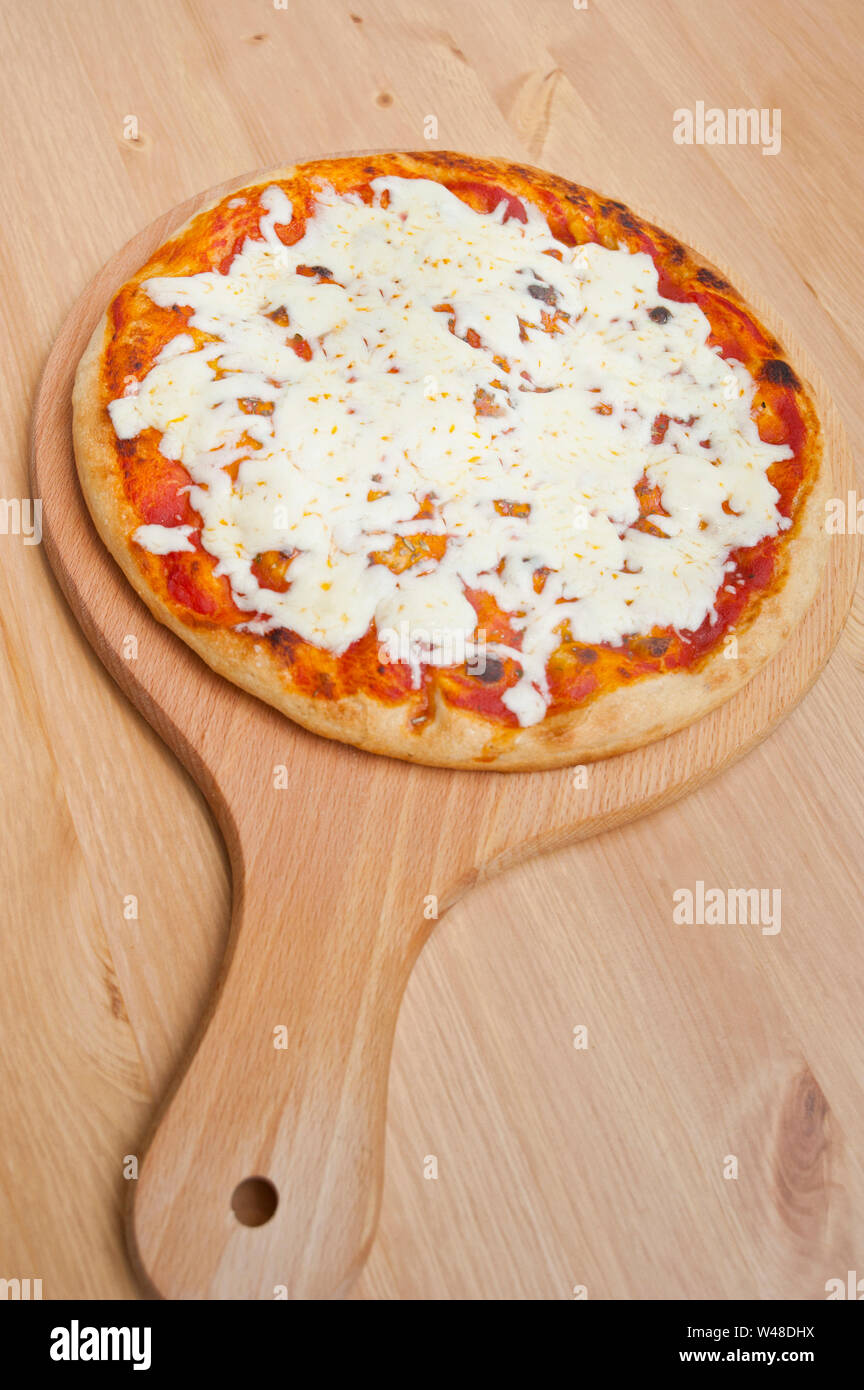 La Pizza Margherita appena il nostro del forno su di un legno tondo vassoio Foto Stock