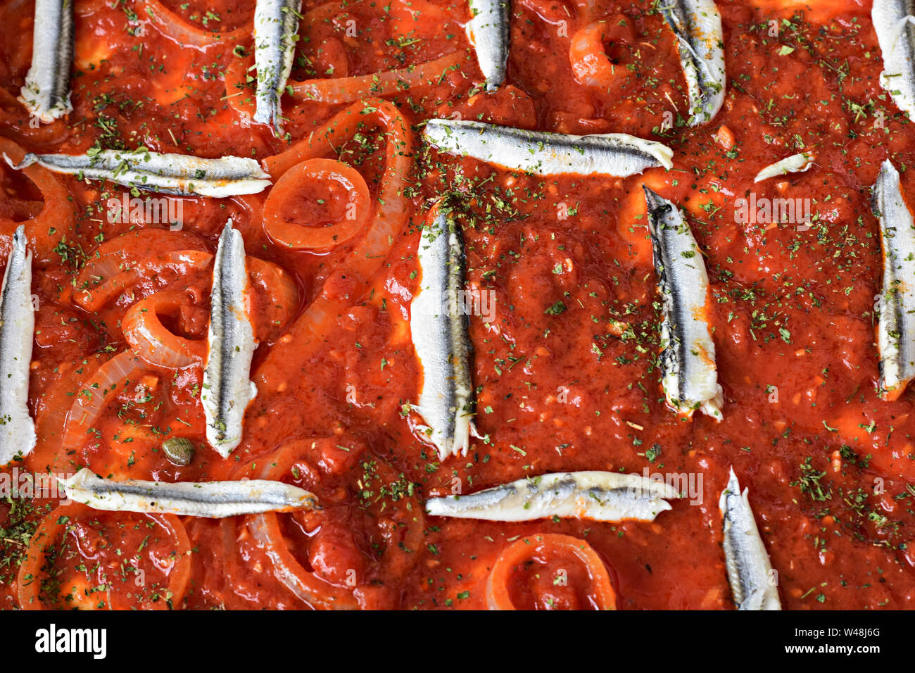 Serviti di sardine con verdure e salsa di pomodoro prezzemolo, su di un tavolo di legno/ cucina mediterranea/ Estate cibo - Immagine Foto Stock