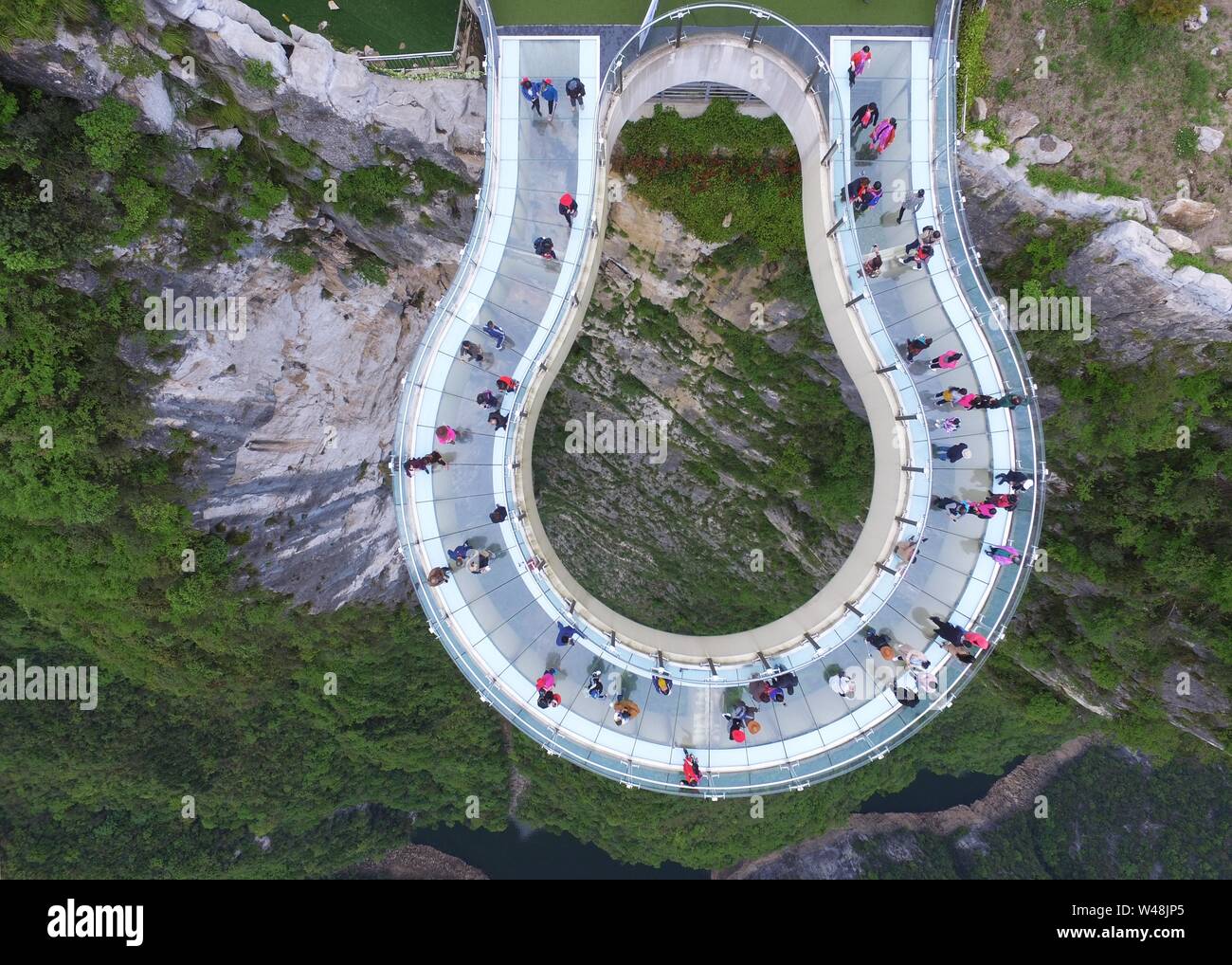 (190721) -- PECHINO, luglio 21, 2019 (Xinhua) -- i turisti visitare la città in modo trasparente a forma di ferro di cavallo ponte a sbalzo al Yunyang Longgang parco geologico, uno 'ossigeno naturale bar,' a Chongqing, sud-ovest della Cina, 14 aprile 2018. Come più e più persone cinesi sono la scelta di visitare i luoghi che hanno aria fresca, fitte foreste e sono ricchi di ioni negativi, ecoturismo diventa una fresca scelta favorita attraverso il paese. Secondo una relazione della Cina Servizio Meteorologico Association, gite alle regioni concessi come 'naturale barre di ossigeno" dall'associazione sono aumentate oltre 200 percento ye Foto Stock