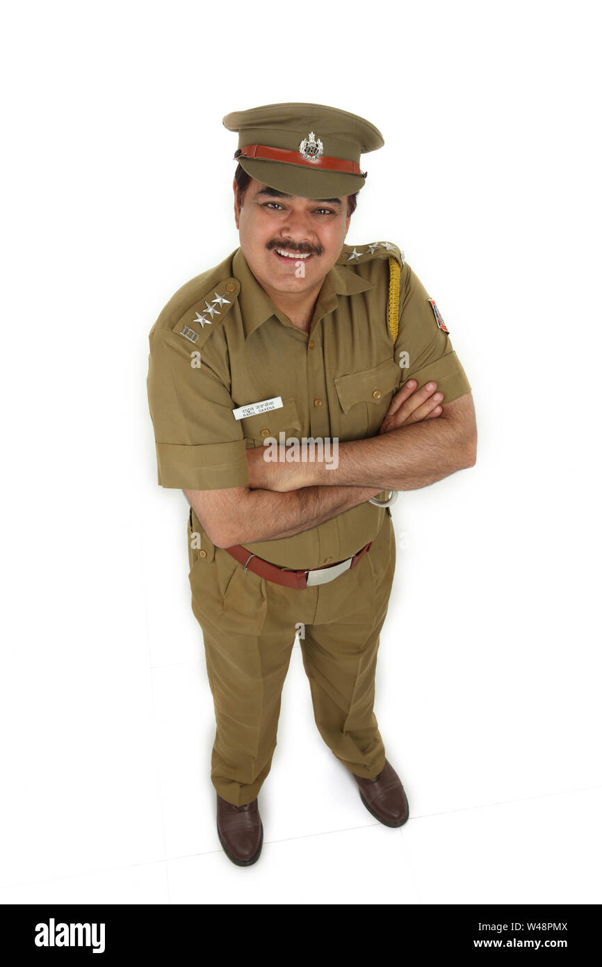 Poliziotto in piedi con le braccia incrociate Foto Stock