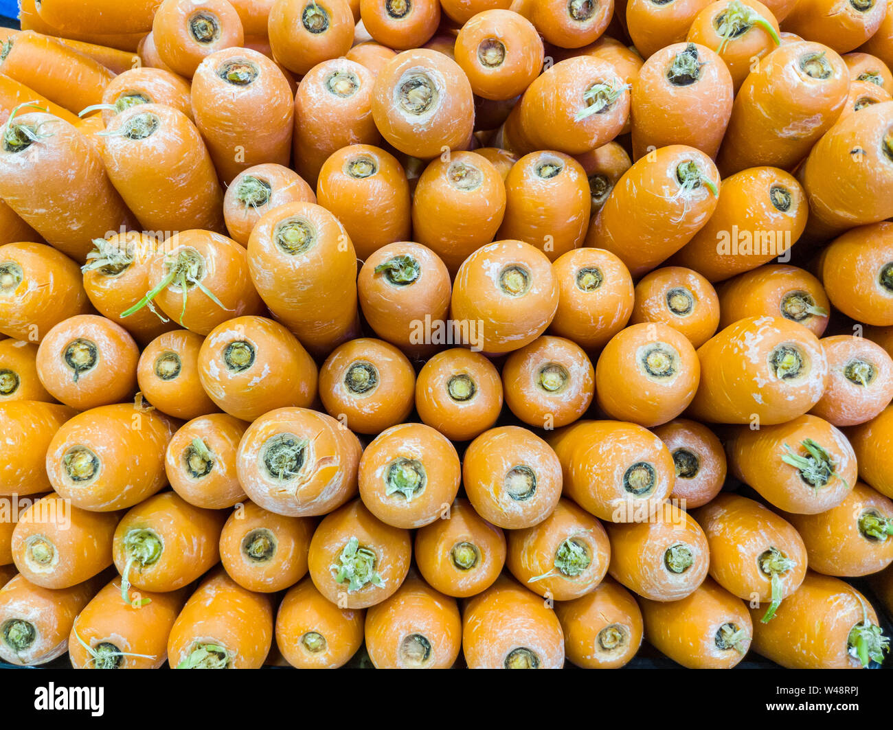 Pila di orange carote in un mercato Foto Stock