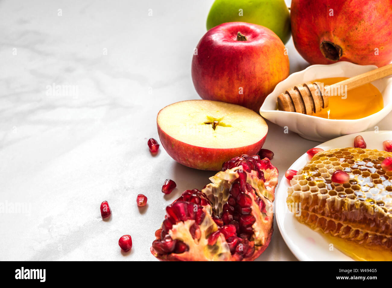 Festa ebraica di Rosh Hashana sfondo con miele, melograno e mele. flat laici. close up con copia spazio. profondità di campo Foto Stock