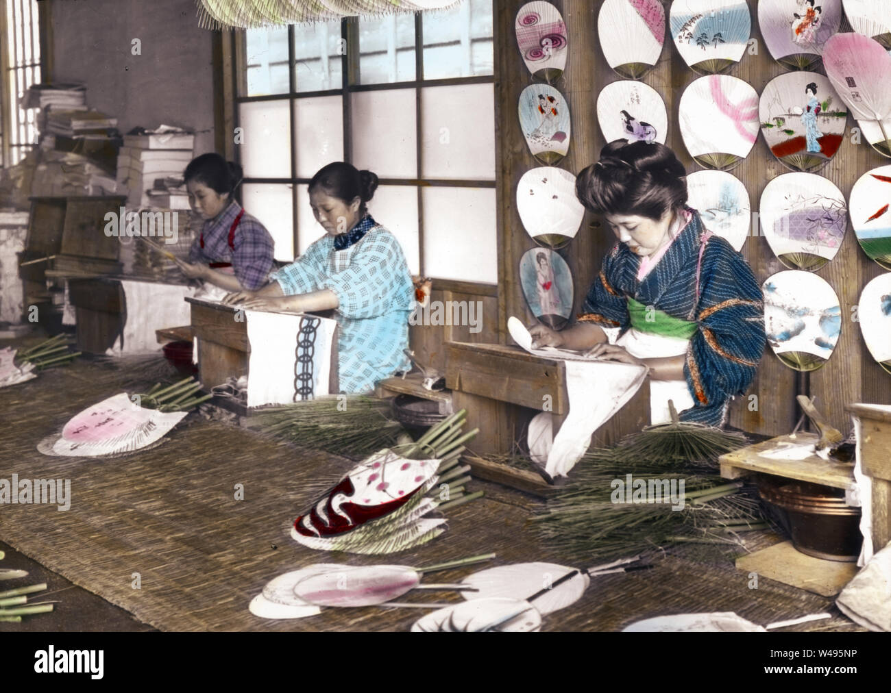 [ 1920s Giappone - Giapponese ventola Makers ] - Giovani donne giapponesi facendo Uchiwa ventole a una piccola fabbrica. Nei primi anni del XX secolo. Xx secolo vintage vetrino di vetro. Foto Stock