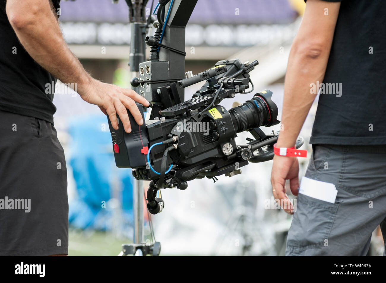 Fotocamera tecnica gli operatori impostano videocamera professionale su una grande gru a braccio, prima di sparare. Foto Stock