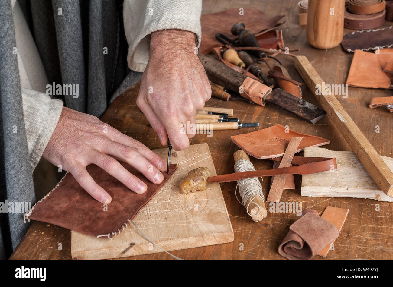 Maestro artigiano opere sulla pelle il suo banco di lavoro Foto Stock