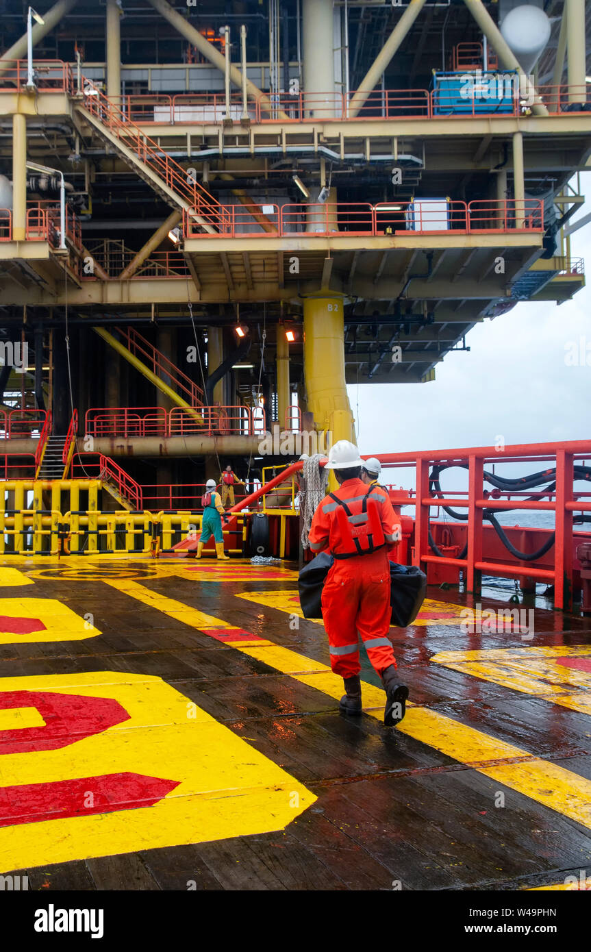 Il personale offshore si prepara alla piattaforma di imbarco indossando DPI completi Foto Stock