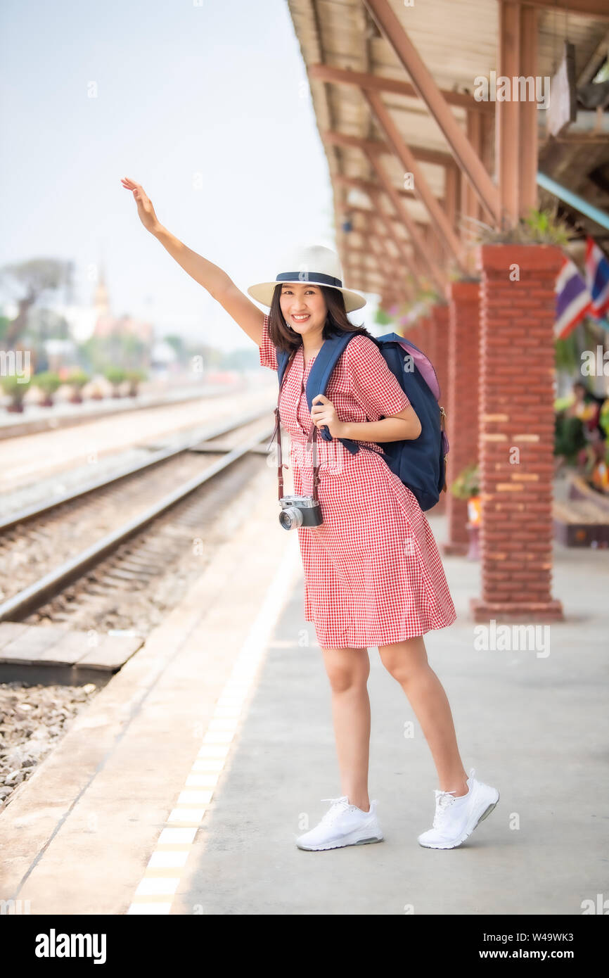 Donne asiatiche turisti portare una fotocamera e sorridente brillantemente presso la stazione ferroviaria. Foto Stock