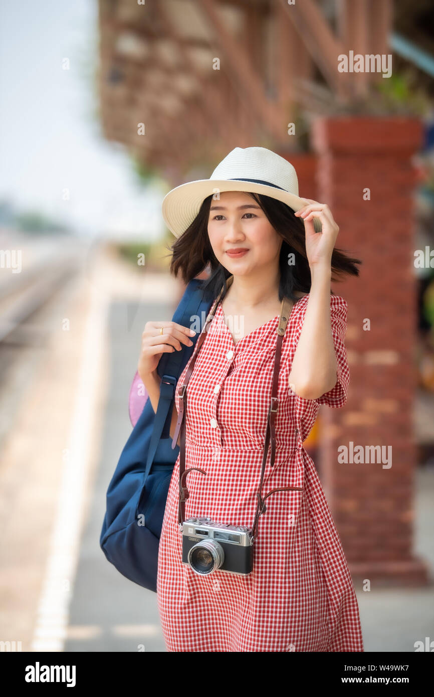 Donne asiatiche turisti portare una fotocamera e sorridente brillantemente presso la stazione ferroviaria. Foto Stock