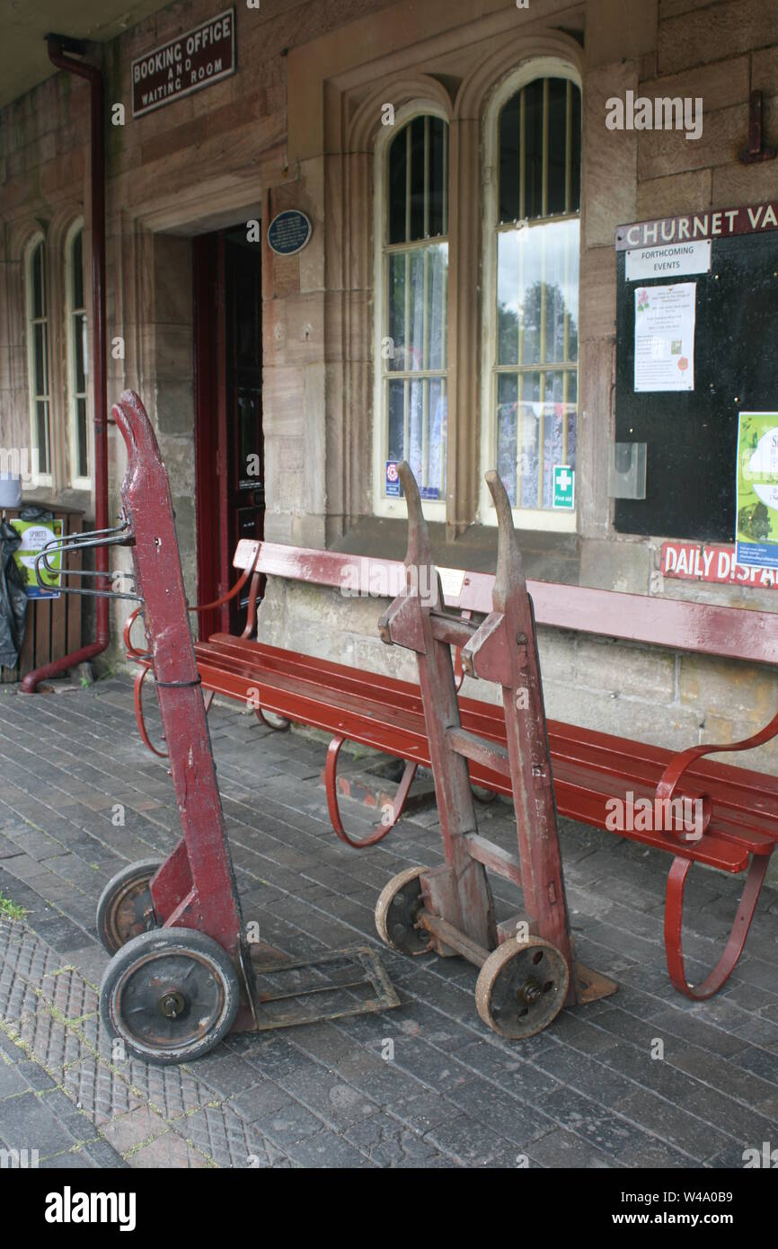 Coppia di sacco vintage carrelli o ferroviarie Carrelli bagagli sulla piattaforma a Cheddleton conserve di stazione ferroviaria Foto Stock