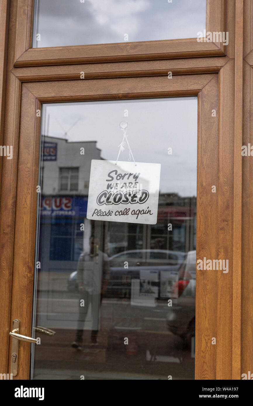 Lettura del segno "Spiacente, siamo chiusi' su shop porta a Tooting, a sud di Londra. Foto Stock