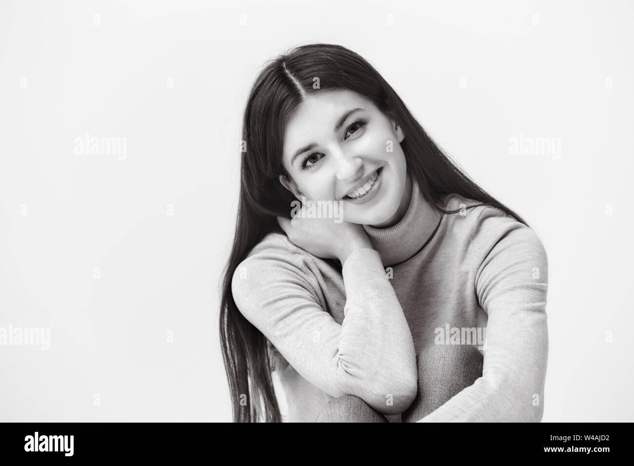 Bianco e nero ritratto di una bella donna caucasica, guardando la telecamera, felice e sorridente Foto Stock