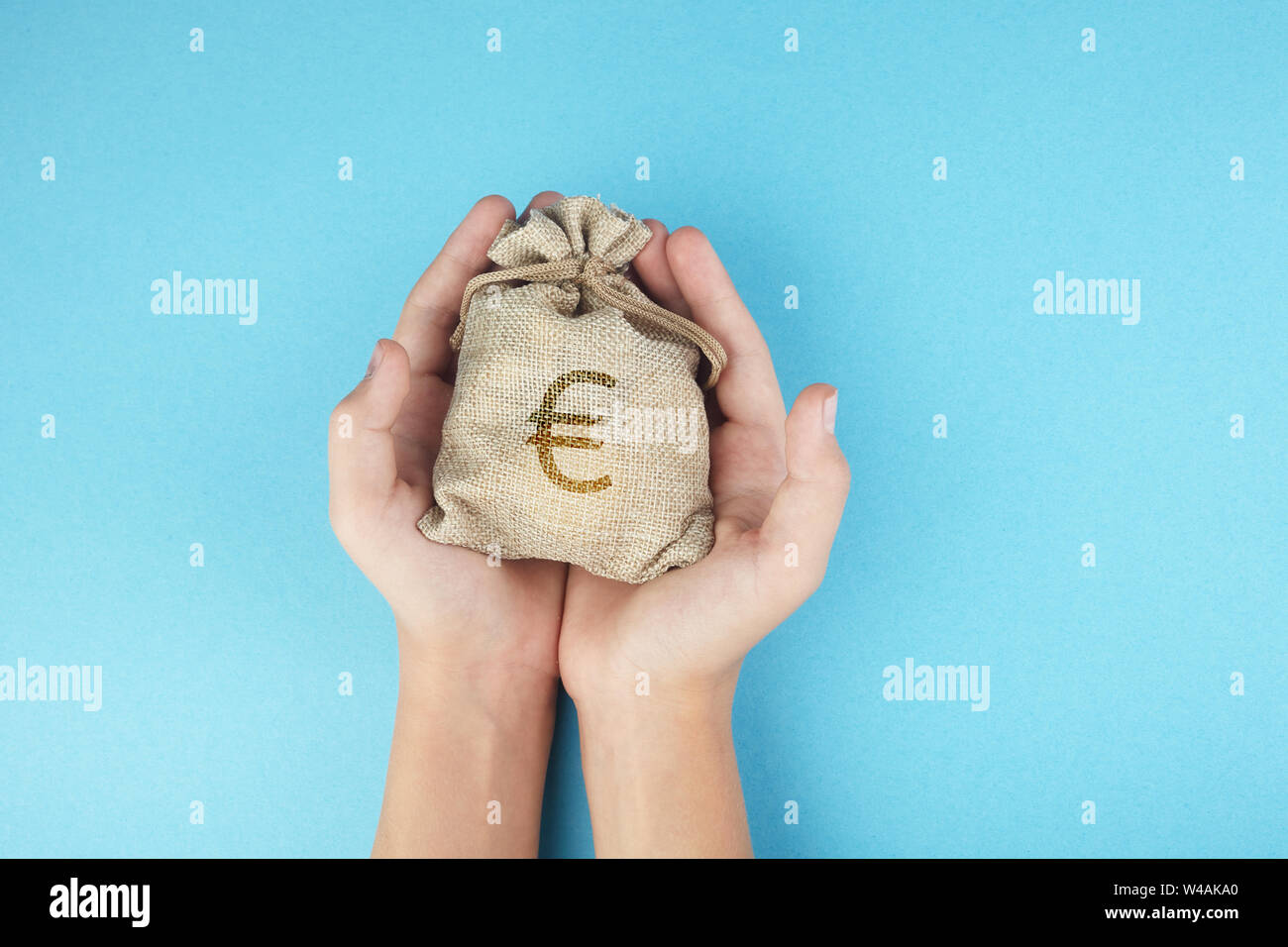 Le donne in attesa di un sacco di denaro su sfondo blu, il risparmio di denaro per il futuro concetto di investimento. Foto Stock