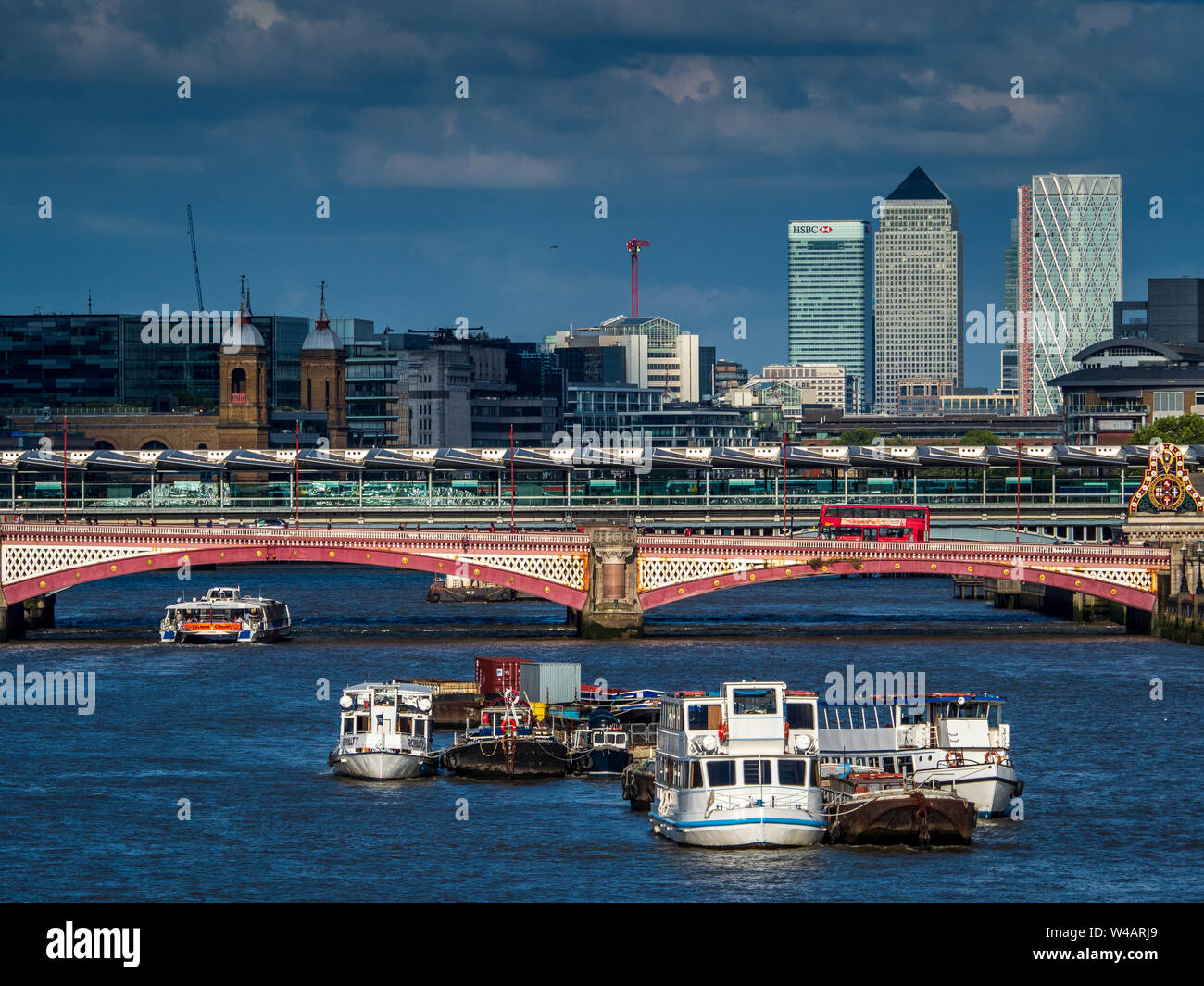 Canary Wharf London contro il cielo scuro. Canary Wharf vista da Londra centrale con Blackfriars Bridge in primo piano Foto Stock