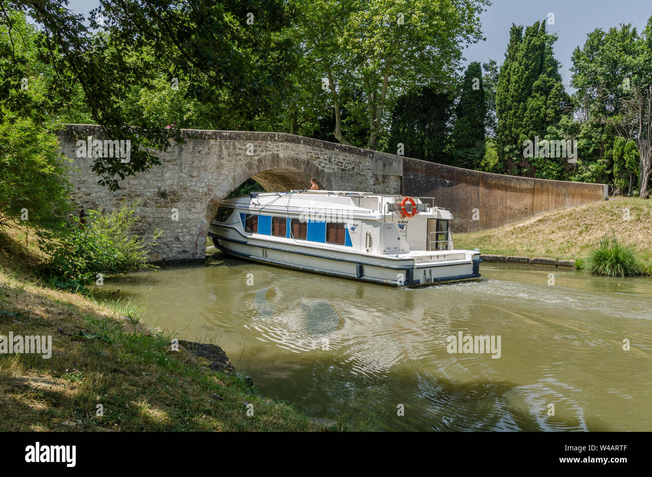 Il piacere di una crociera in barca lungo il Canal du Midi, Francia, andando al di sotto di un ponte sul canale Foto Stock