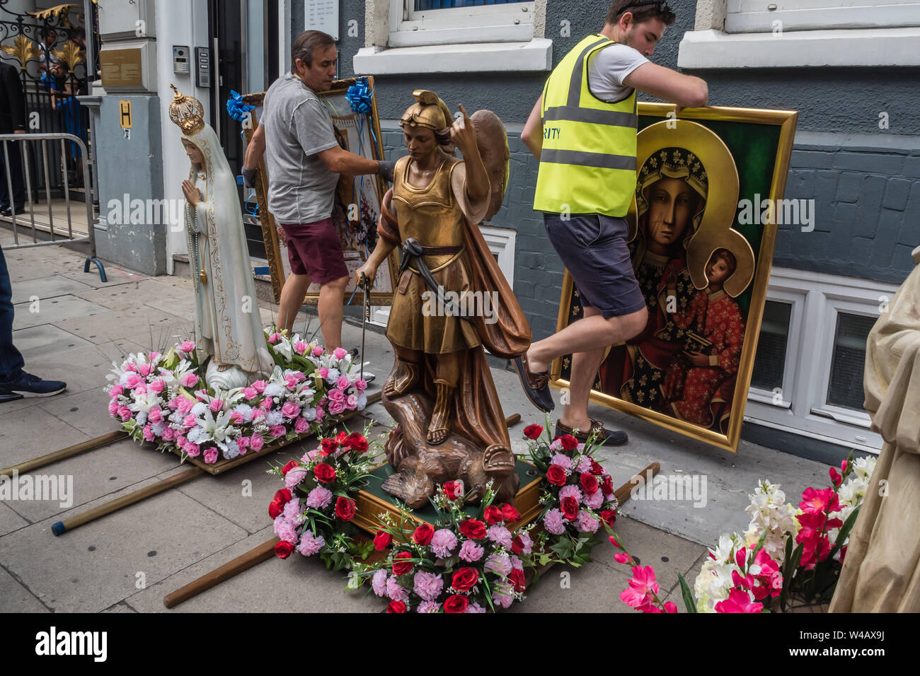 Londra, Regno Unito. Il 20 luglio 2019. Le icone sono portati fuori e mettere con le statue per il corteo storico nella zona londinese di Clerkenwell dalla Basilica di San Pietro la Chiesa italiana, la processione annuale in onore di Nostra Signora del Monte Carmelo ha avuto luogo ogni anno dal momento che è stato dato il permesso speciale nel 1883. Le statue dei Santi vengono portati fuori dalla chiesa e portati in giro per l'area lungo con sette galleggianti biblica e vari gruppi a piedi tra cui alcuni in abito biblica e nuovo communicants. Tre colombe sono stati rilasciati come clero unito la processione e furono seguiti dai parrocchiani. Peter Marshall/al Foto Stock
