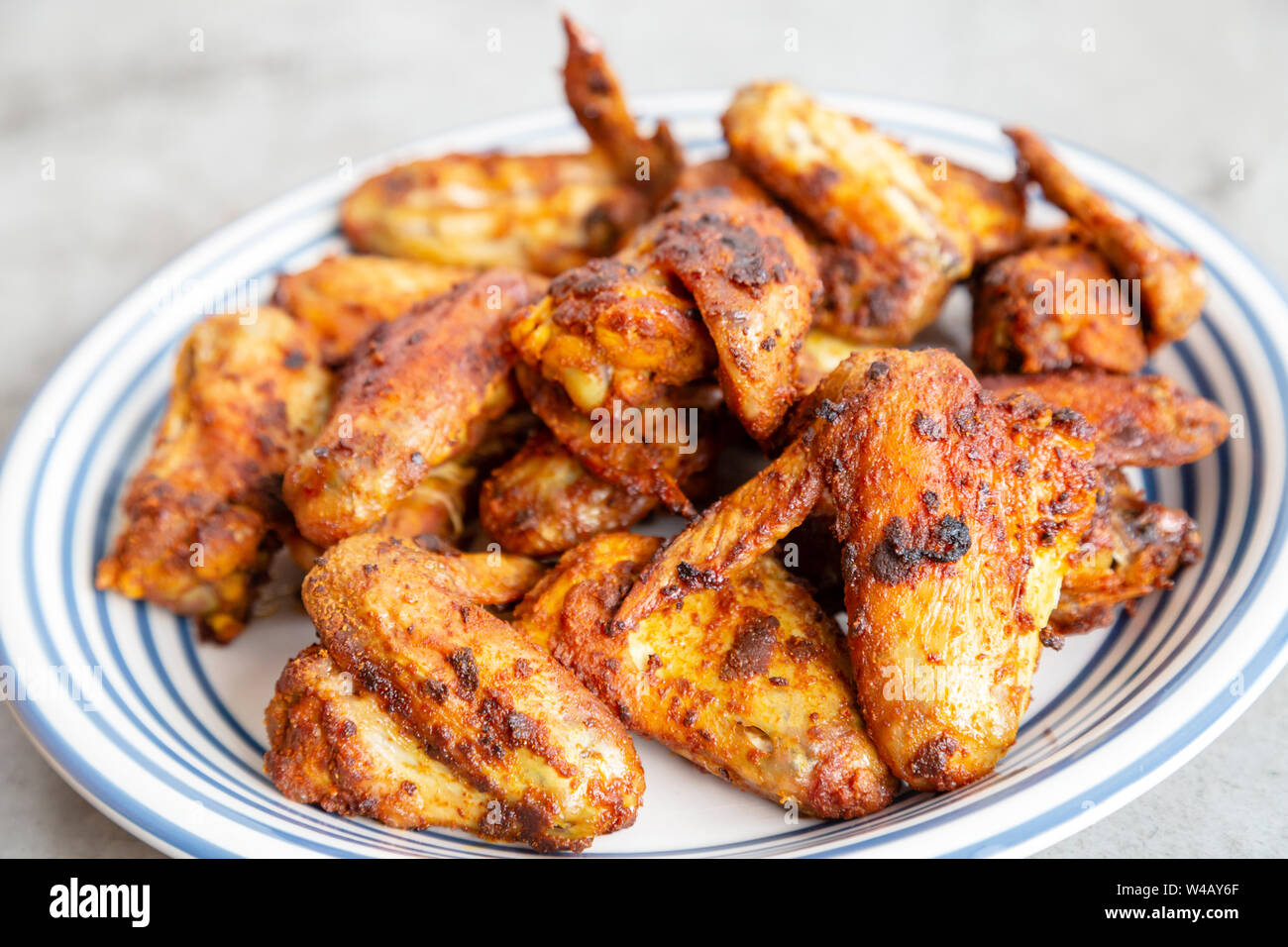 Grigliata di ali di pollo con un secco rub marinata di curry in polvere e la curcuma. Foto Stock