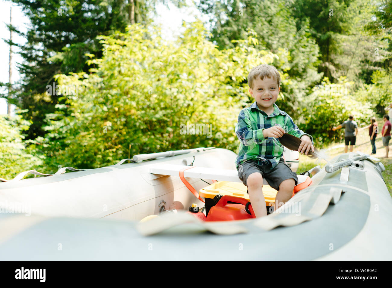 Dritto il ritratto di una giovane ragazzo giocando su una barca su un rimorchio Foto Stock