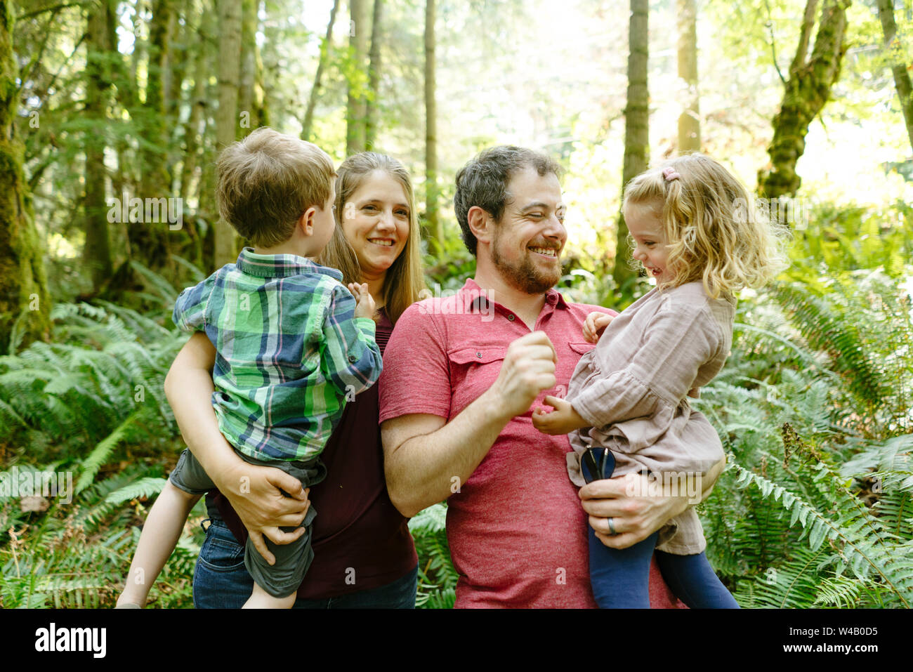 Ritratto di una giovane famiglia di quattro nella foresta Foto Stock