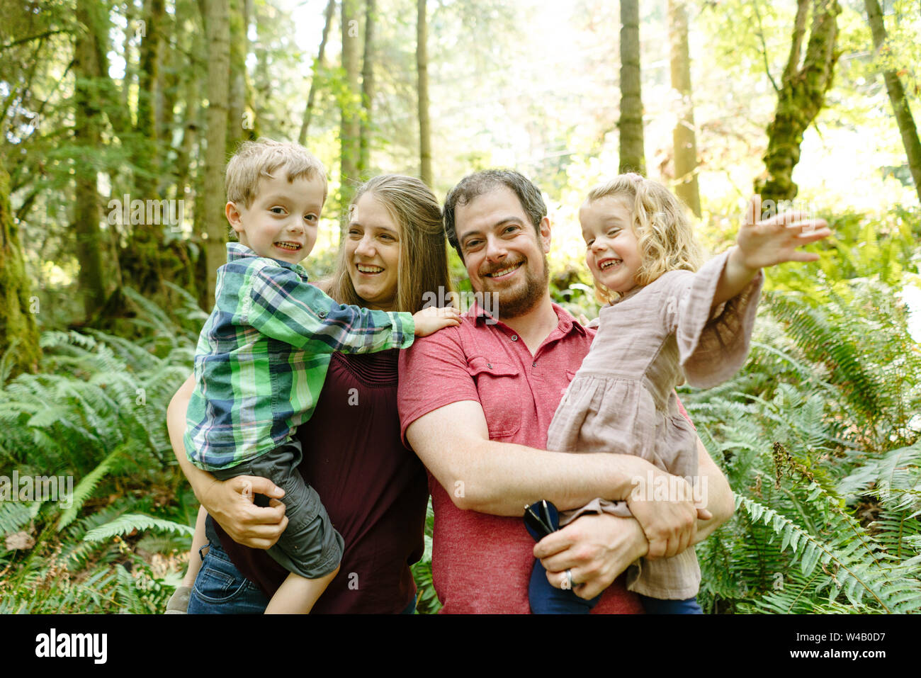 Dritto il ritratto di una famiglia di quattro persone nel bosco Foto Stock