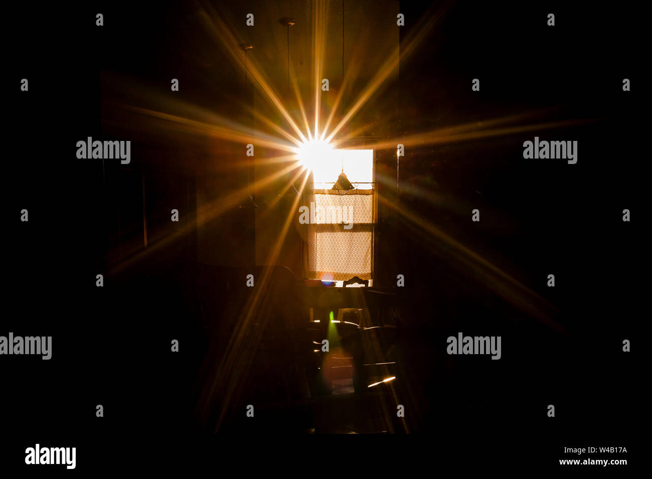 Starburst raggi di luce di entrare a casa attraverso la finestra Foto Stock