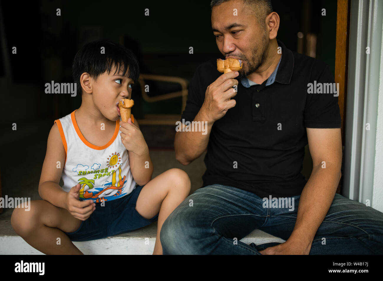 Ragazzo e padre a mangiare il gelato Foto Stock