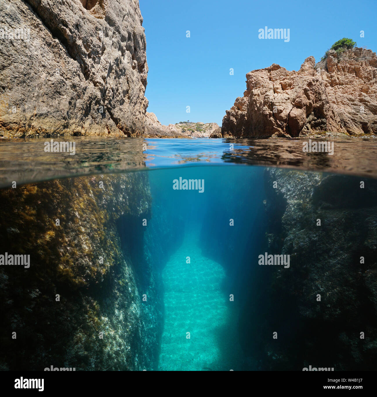 Passaggio stretto tra le rocce in riva al mare, la vista suddivisa al di sopra e al di sotto di acqua, mare Mediterraneo, spagna Costa Brava, Palafrugell, Catalogna Foto Stock