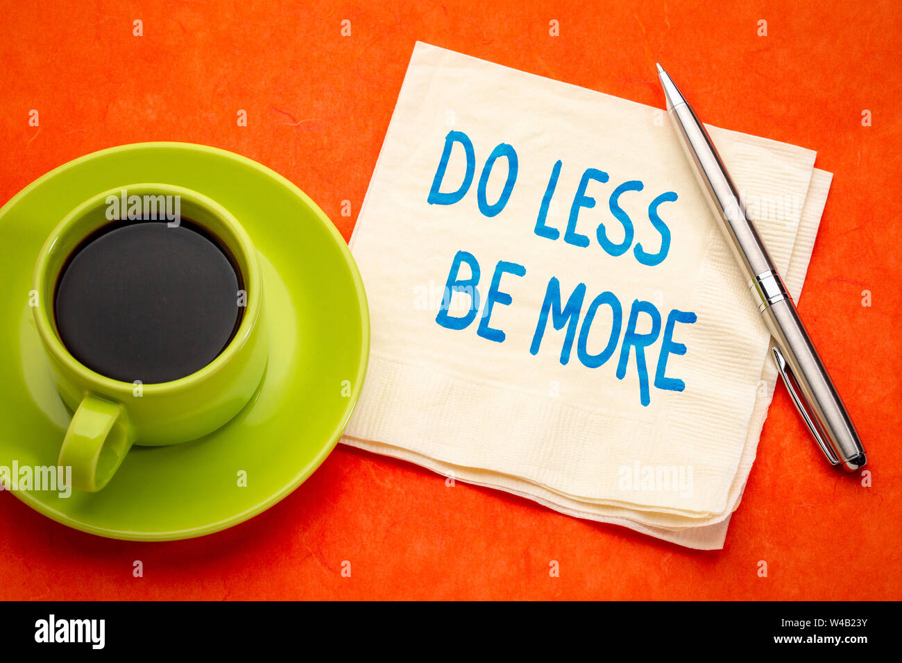Fare meno, essere più consigli di ispirazione - scrittura su un tovagliolo con una tazza di caffè Foto Stock