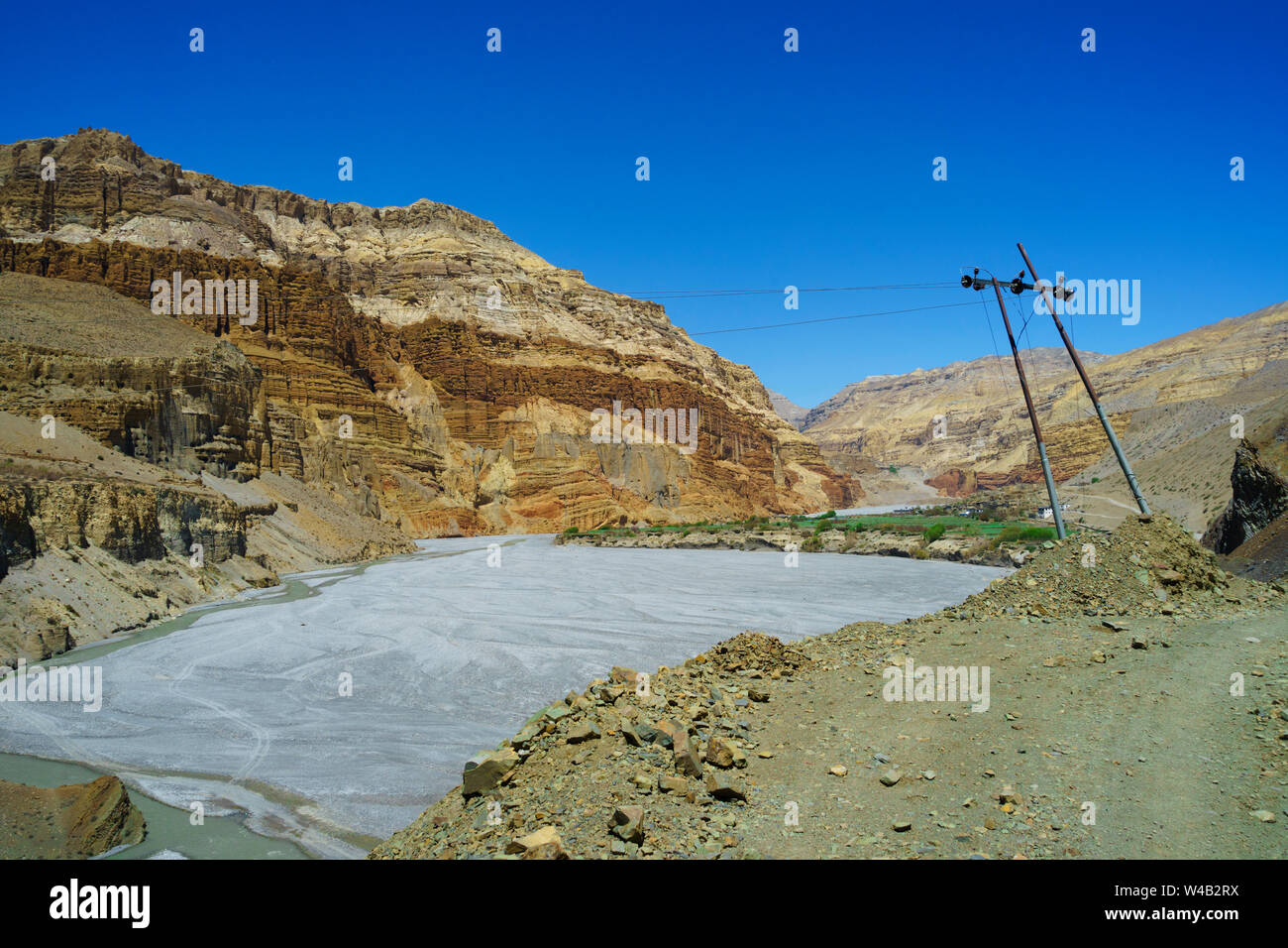 Le linee elettriche di alimentazione sulla strada per il borgo antico di Chuksang, visibile in background. Mustang Superiore regione, Nepal. Foto Stock