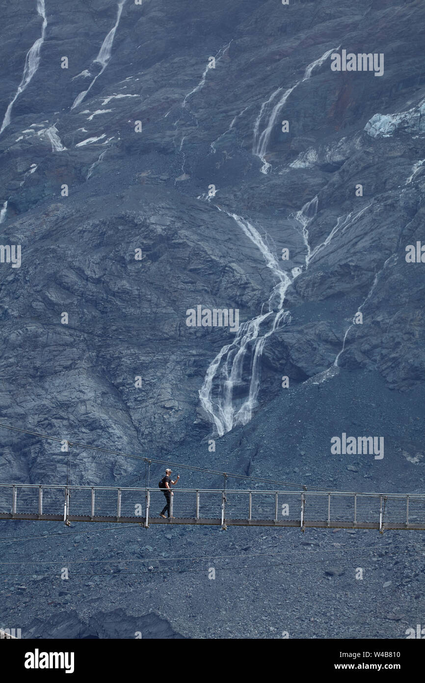 Escursionista sul fiume Hooker passerella & Mt Sefton, Aoraki / Mt Cook National Park, Canterbury, Isola del Sud, Nuova Zelanda Foto Stock