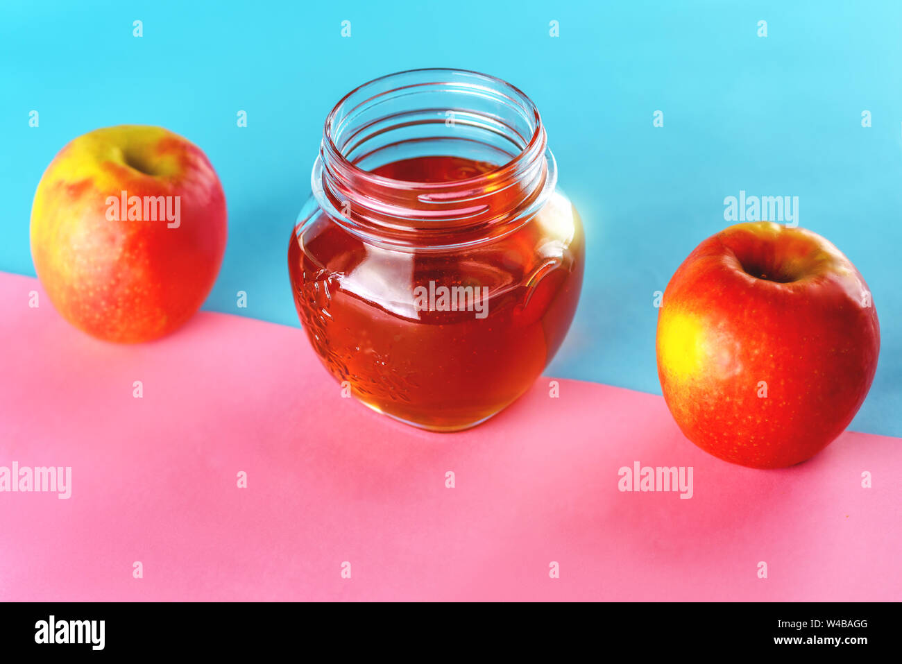 Due mele e miele vaso blu su sfondo rosa. Cibo sano. Ingredienti frullato. Foto Stock