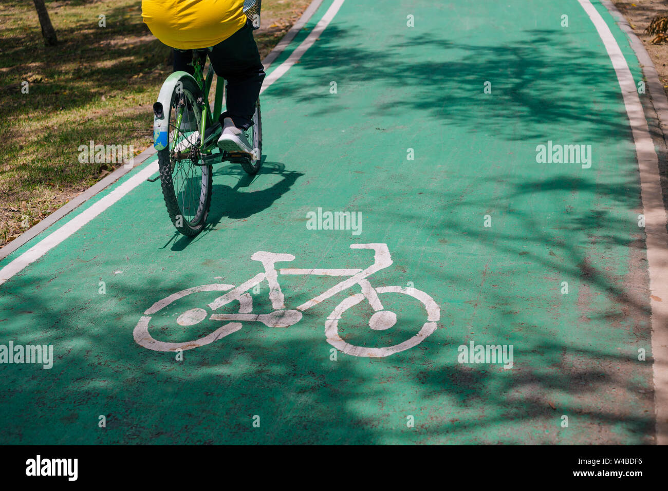 Irriconoscibile biker ciclismo su bici verde lane durante l'estate. Green Trasporti Foto Stock