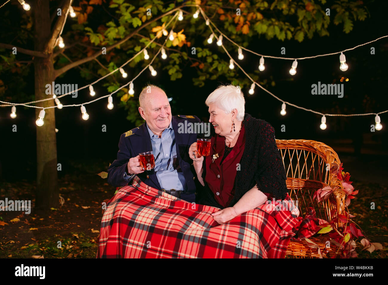 Felice coppia senior di bere il tè la sera seduti sul divano Foto Stock