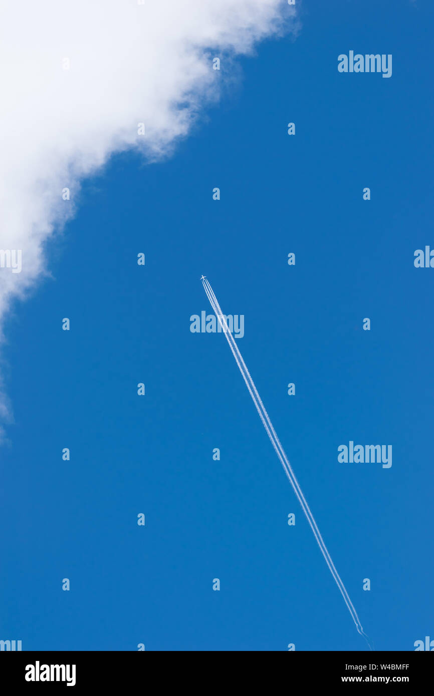 Cielo blu e aereo con contrail - colpo verticale Foto Stock