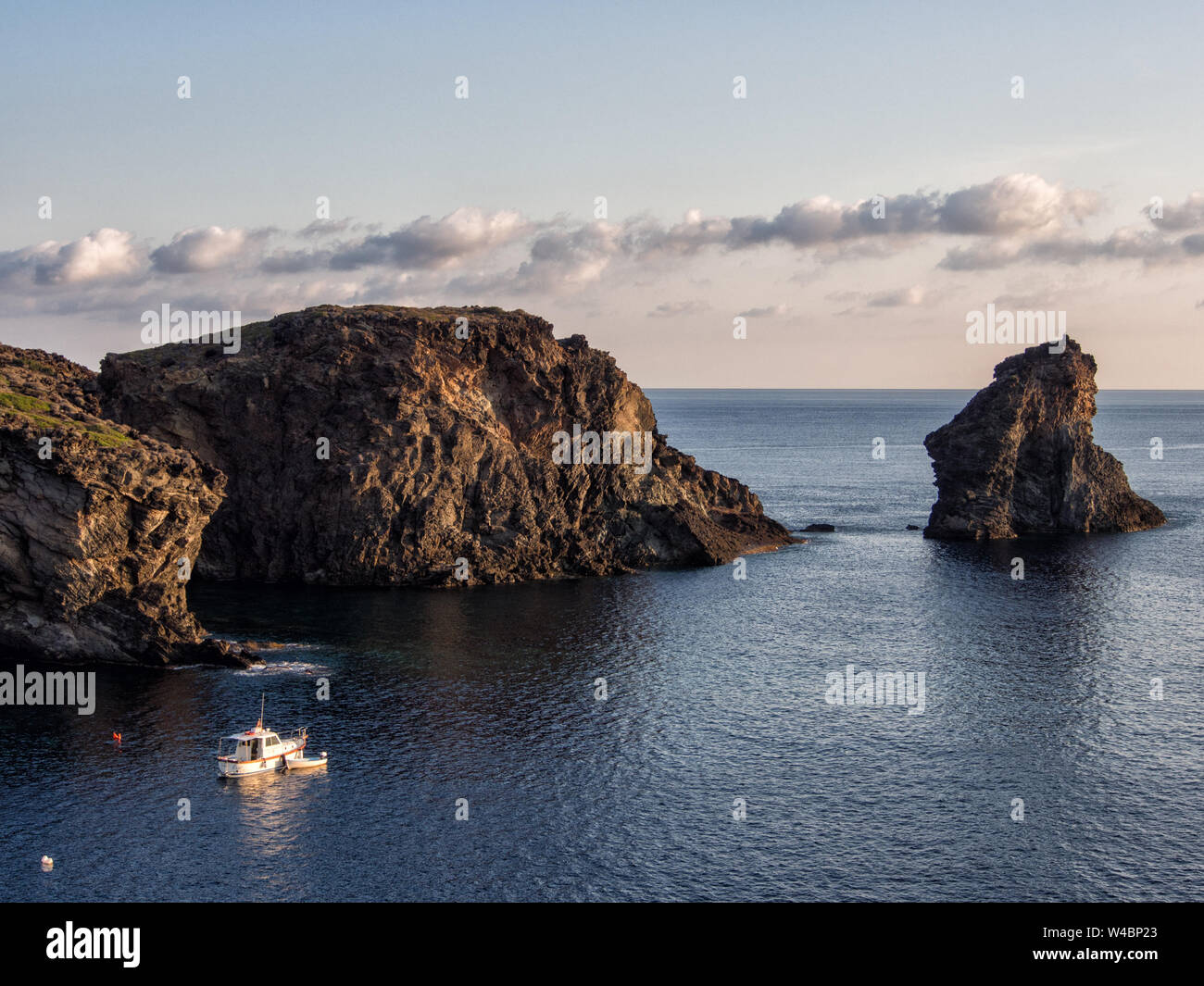 Barca e rocce nel mare mediterraneo. Isola di Pantelleria, Italia Foto Stock