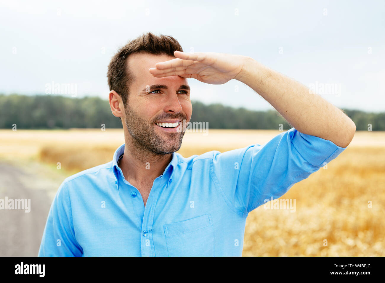 Ritratto di un giovane uomo che guarda avanti felicemente Foto Stock