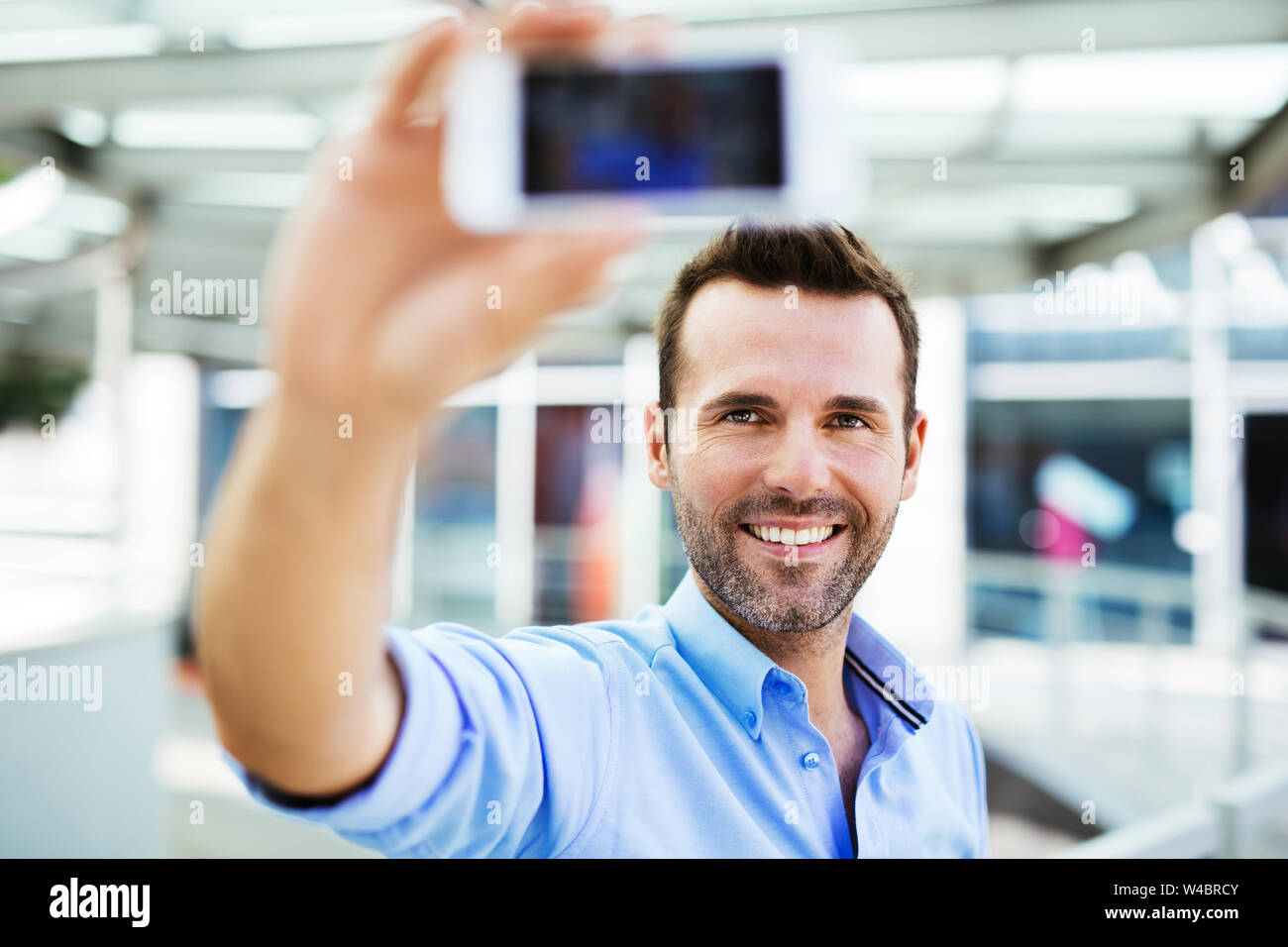 Bel uomo prendendo selfie fuori dall'ufficio Foto Stock