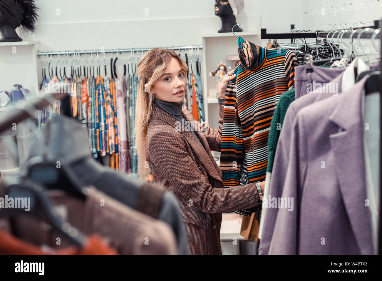 Imprenditrice guardando striped polo collo mentre lo shopping Foto Stock