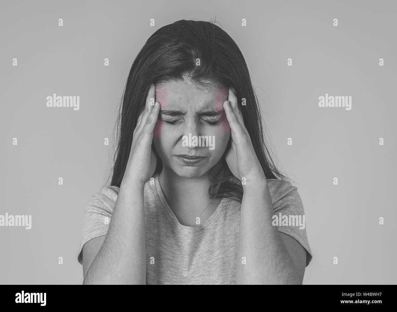 Bianco e nero ritratto di una giovane donna triste, seri e interessati, guardando preoccupata e premurosa che soffre di emicrania. Isolato su folle bac Foto Stock