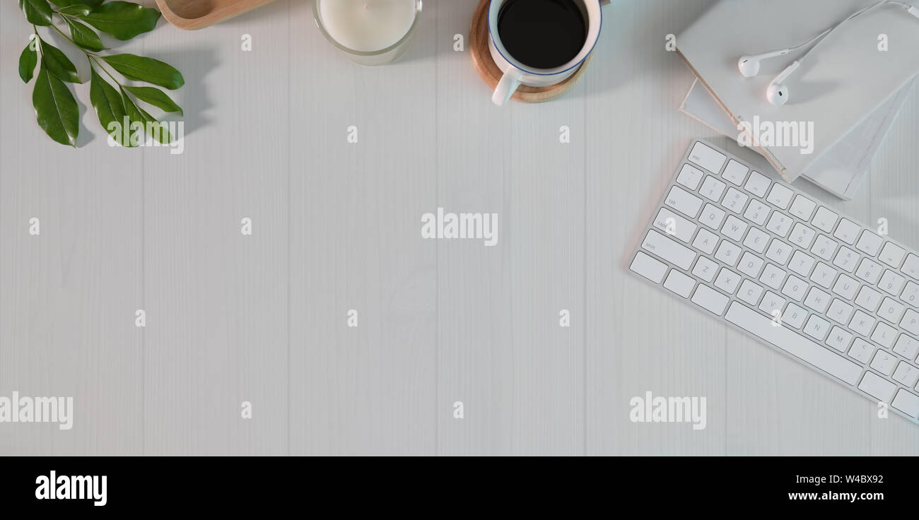 Tettuccio a corto di freelancer il minimo spazio di lavoro con forniture per ufficio su bianco tavolo in legno Foto Stock