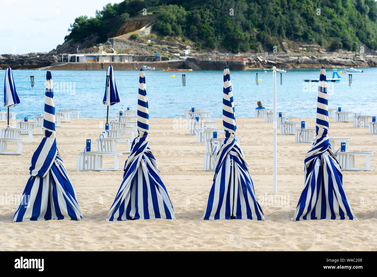 Blu e bianchi ombrelloni della spiaggia di Ondarreta, San Sebastian, Spagna Foto Stock