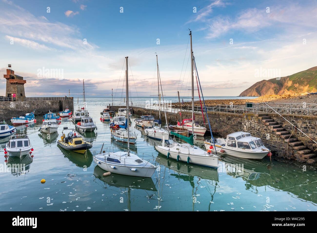 Una serata estati nella pittoresca North Devon villaggio costiero di Lynmouth come le piccole barche nel porto salire sulla marea. Foto Stock