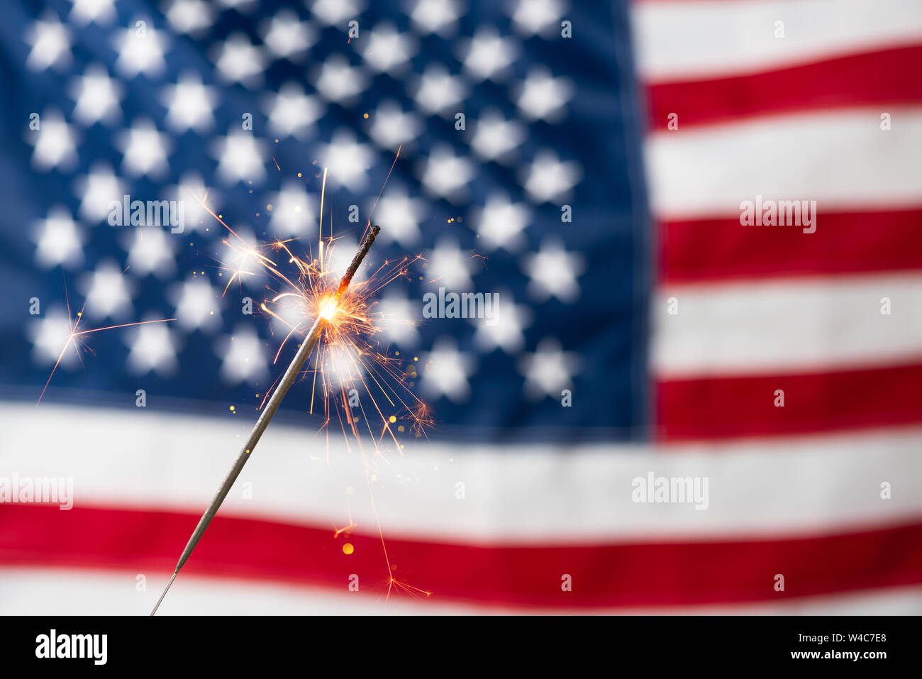 Parte sparkler e USA bandiera americana. Il 4 luglio il giorno di indipendenza celebrazione bruciare fuoco bengala e United States Flag. Foto Stock