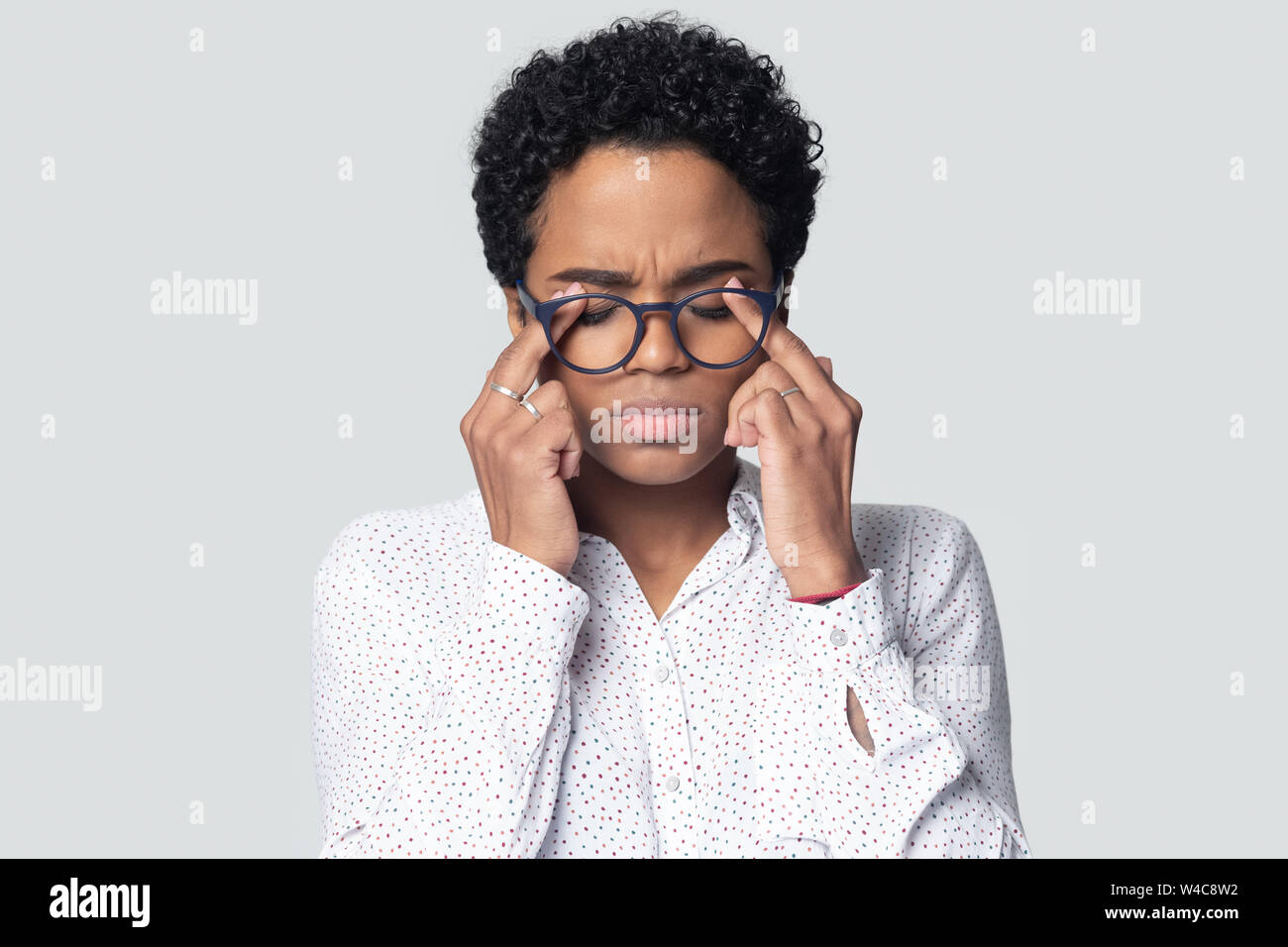 Esaurito americano africano massaggio donna occhi affetti da mal di testa Foto Stock